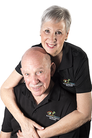 Doris Fink and Artie, co-owners of A-Z Home Watch Solutions, smiling together in matching branded polo shirts, promoting professional home watch services.